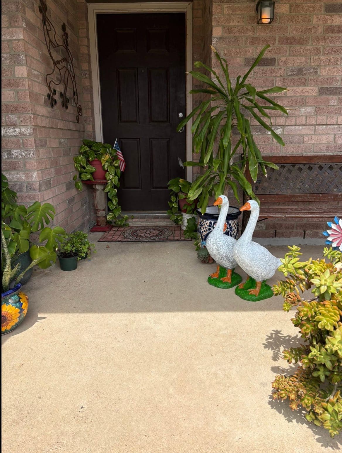 Two classic geese standing guard on a front porch